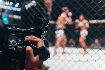 Professional sports cameraman recording boxing match