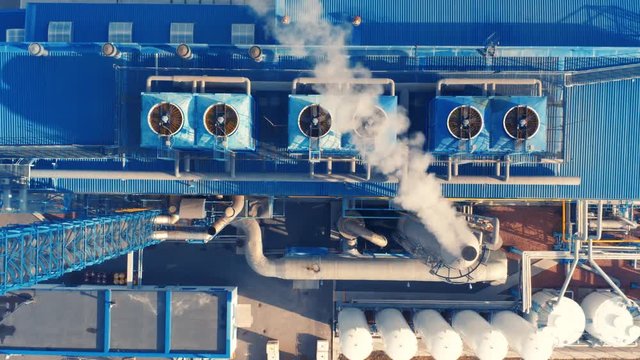 Aerial top view of the modern factory territory with fuming pipe