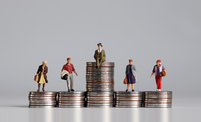 Social stratification concept. Miniature people with stack of coins.