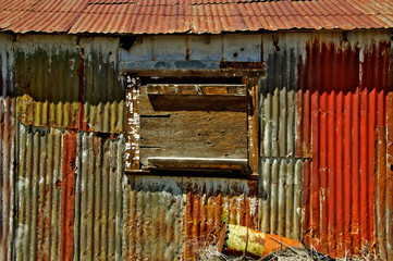 Old Corrugated Metal Shed with peeling paint and boarded window in the mining town of Ruth, Nevada 