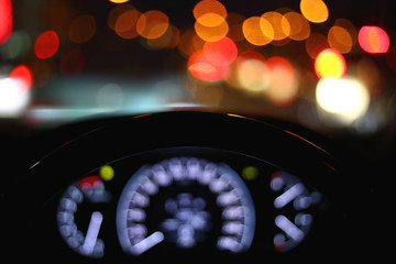 black steering wheel inside car drive in night city street