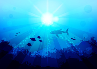 shark and small fish are circling under the water illuminated by sunlight and rays, view with the bottom of the ocean