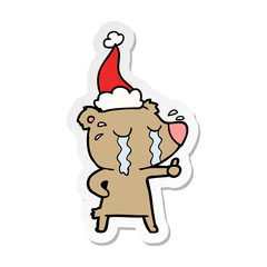 sticker cartoon of a crying bear wearing santa hat