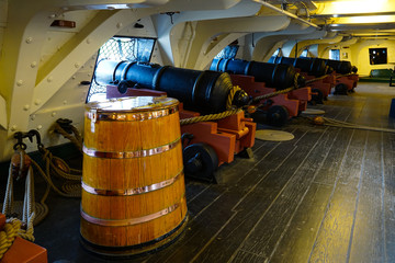 Row of cannons and gunpowder barrel on the ship USS Constitution.