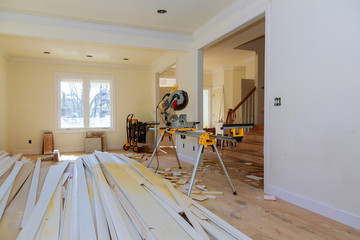 Construction remodeling home cutting wooden trim board on with circular saw.