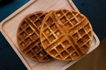 two waffles on wooden plate