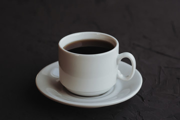 White cup of coffee on a dark background