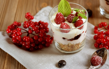 Happy breakfast - yogurt with muesli and berries on a wooden table