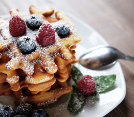 Blueberry waffles with raspberries anв sugar powder for breakfast