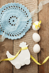 Rustic Easter background with wooden decorative chicken and chicken eggs on old vintage wooden board with blank space for text