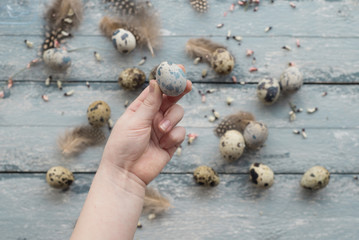 Fototapeta na wymiar Easter background, small children hands hold quail eggs