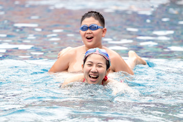 mom and son enjoy playing in pool