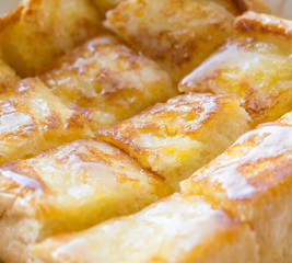 Closeup picture of one bread with butter and sweet milk in paper plate.