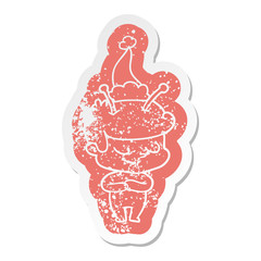 friendly cartoon distressed sticker of a spaceman wearing santa hat