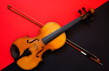 Fototapeta premium Violin and bow on a red and black background
