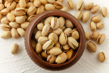 Bowl of pistachio close up, and pistachio on a kitchen table, view from the above