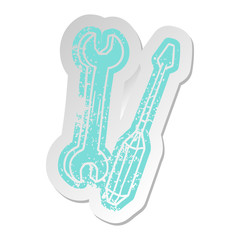 distressed old sticker of a spanner and a screwdriver