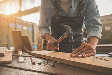 Carpenter working with equipment on wooden table in carpentry shop. woman works in a carpentry shop.