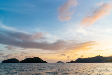 Fototapeta na wymiar Green islands and reflected sea wave with blue, yellow sky color in background in the evening in Koh Mak Island at Trat, Thailand.