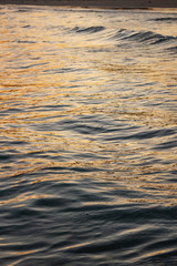 Sea wave surface that reflected with blue, yellow sky color in the evening in Koh Mak Island at Trat, Thailand.