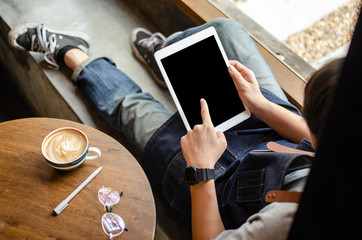 man using tablet on wooden table