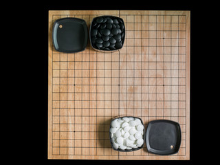 top view of wood board with black white stones,Go game(Weiqi,Baduk),Traditional asian strategy board game isolated on balck background