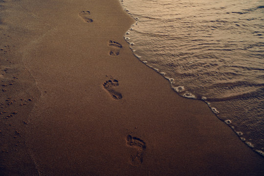 footprints on the dark beach