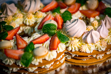Light and fresh cake. Refined dessert made from meringue topped with low-fat whipped cream, mint leaves and strawberries