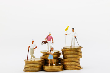 Miniature people: Golfers hit golf balls up to the top coins,  Finance, investment and growth in business concept.
