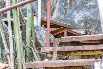 Close-up Stairs made of steel to the limestone mountains At the edge of a cliff side With bamboo cover.