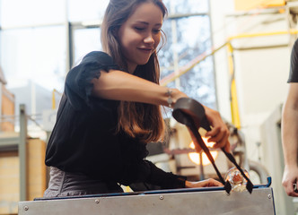 A glassblower student tries to make a flower out of glass