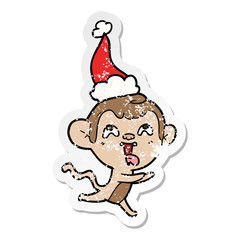 crazy distressed sticker cartoon of a monkey running wearing santa hat