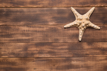 Summer background, starfish on wooden boards.
