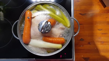 Vegetables and chicken cooking in a metal pot