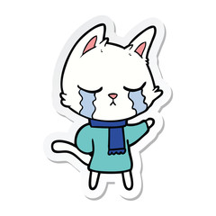 Obraz na płótnie Canvas sticker of a crying cartoon cat wearing winter clothes