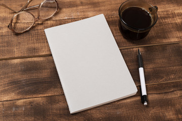 top view image of open notebook with blank pages next to cup of coffee on wooden table. ready for...