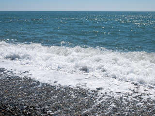 Wave splash on pebble beach. Sea landscape