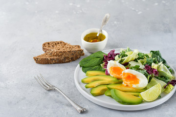 food for a healthy Breakfast or lunch. salad of avocado, kale leaves, egg and spinach, on a white plate, grain bread, diet food, organic vegetables, food flat lay