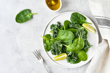 green salad of organic spinach and kale leaves with lemon juice and olive oil. diet menu concept,...