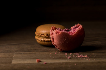 Naklejka na ściany i meble Macaron with bite mark, Pink and Brown Macarons on wooden table, breakfast in morning light