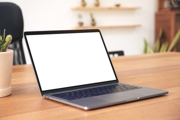 Fototapeta premium Mockup image of laptop with blank white desktop screen on wooden table