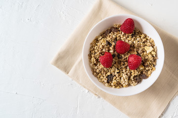 Organic granola with fresh berries on white background , flat lay.
