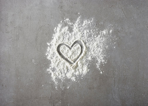 heart shape in flour on grey kitchen table - Powered by Adobe