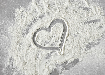 heart shape in flour on grey kitchen table