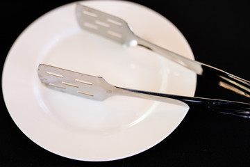 The tableware, stainless spoon and fork, in a wicker basket on the wooden table