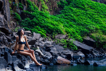 Girl in black swimsuit at amazing Waterfall india wildernest dudhsagar