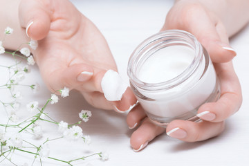 Cosmetic natural cream in a jar on a white table background.