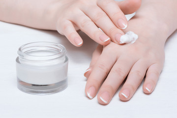 Cosmetic natural cream in a jar on a white table background.