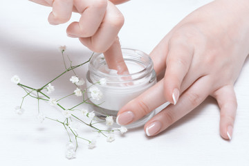 Cosmetic natural cream in a jar on a white table background.