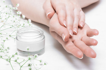 Fototapeta premium Cosmetic natural cream in a jar on a white table background.